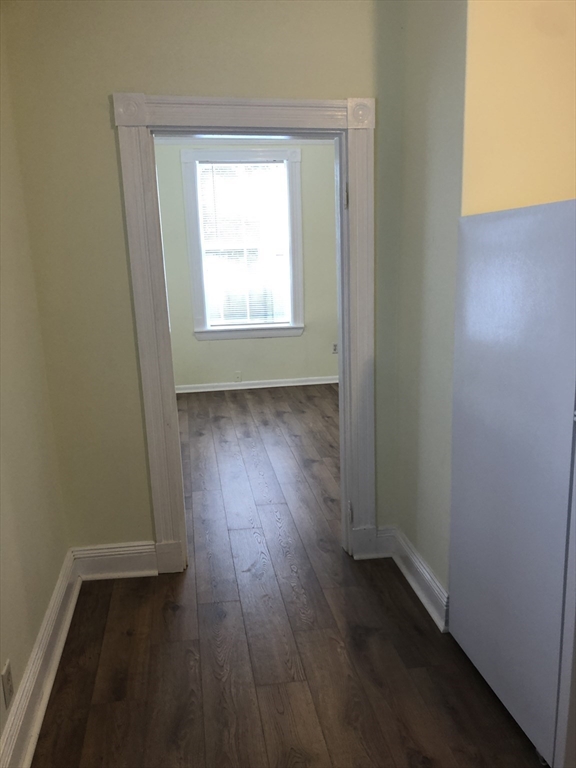 6 Rowley Street, Unit 1R Boston, MA 02122 - Photo 5 of 9 an empty room with wooden floor and windows