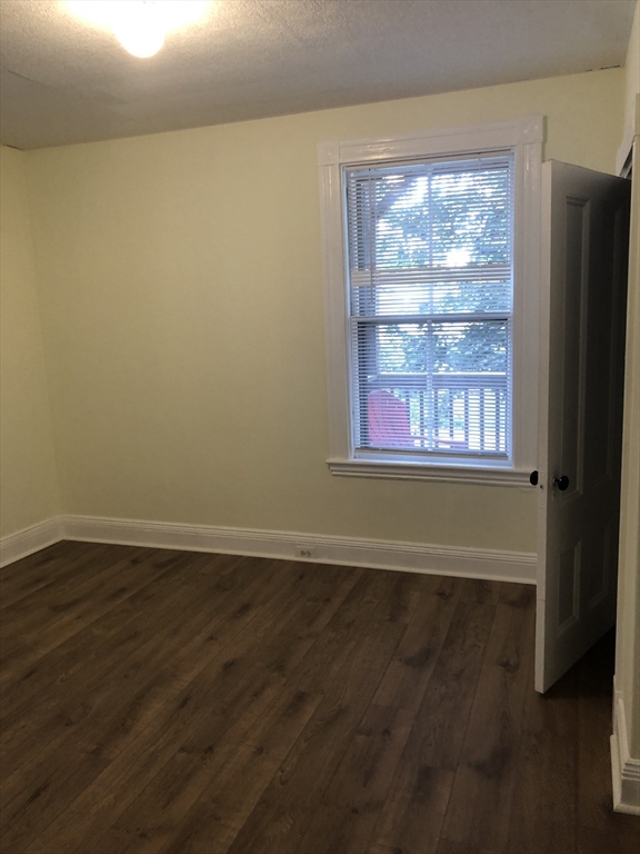 6 Rowley Street, Unit 1R Boston, MA 02122 - Photo 7 of 9 a view of an empty room with wooden floor and a window