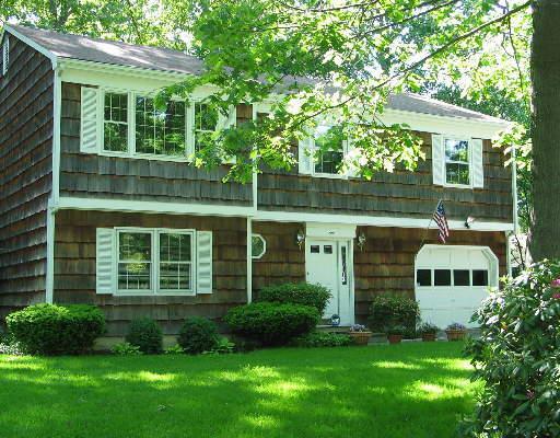 a front view of a house with a yard and trees