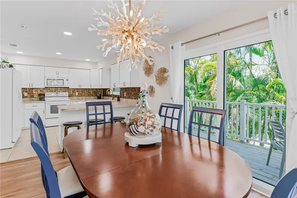 a dining room with furniture a chandelier and wooden floor