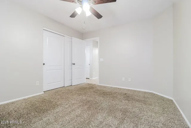 an empty room with a chandelier fan