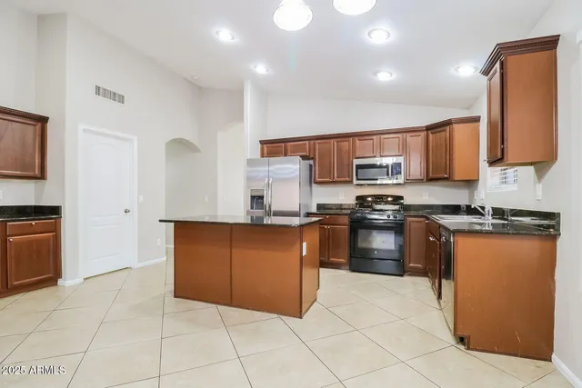 a kitchen with stainless steel appliances granite countertop a stove top oven a sink a counter top space and cabinets