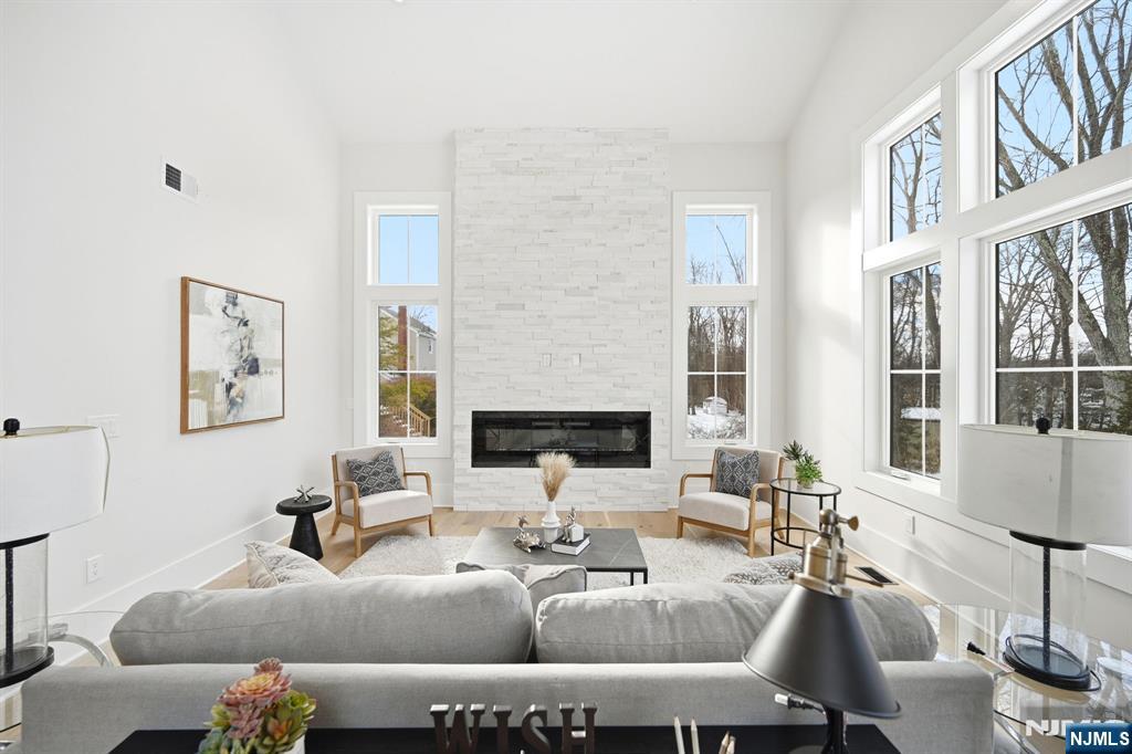 8 Montgomery Road Livingston, NJ 07039 - Photo 14 of 38 a living room with furniture a fireplace and a large window
