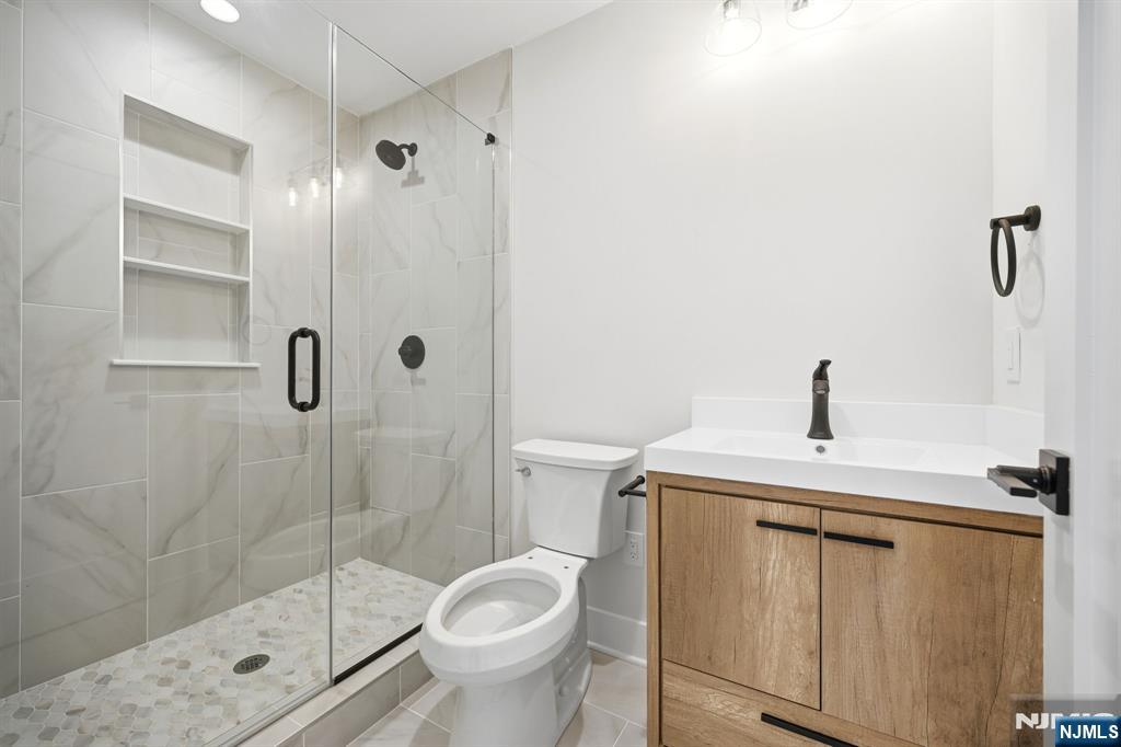 8 Montgomery Road Livingston, NJ 07039 - Photo 18 of 38 a bathroom with a shower a toilet and sink