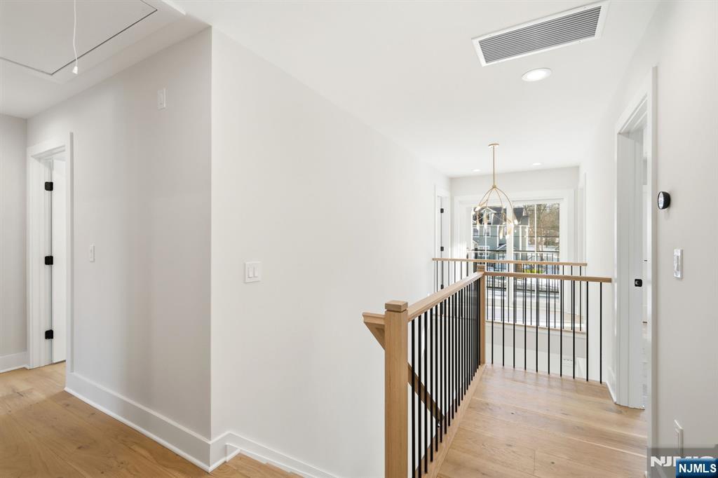 8 Montgomery Road Livingston, NJ 07039 - Photo 19 of 38 a view of a hallway with wooden floor and fence