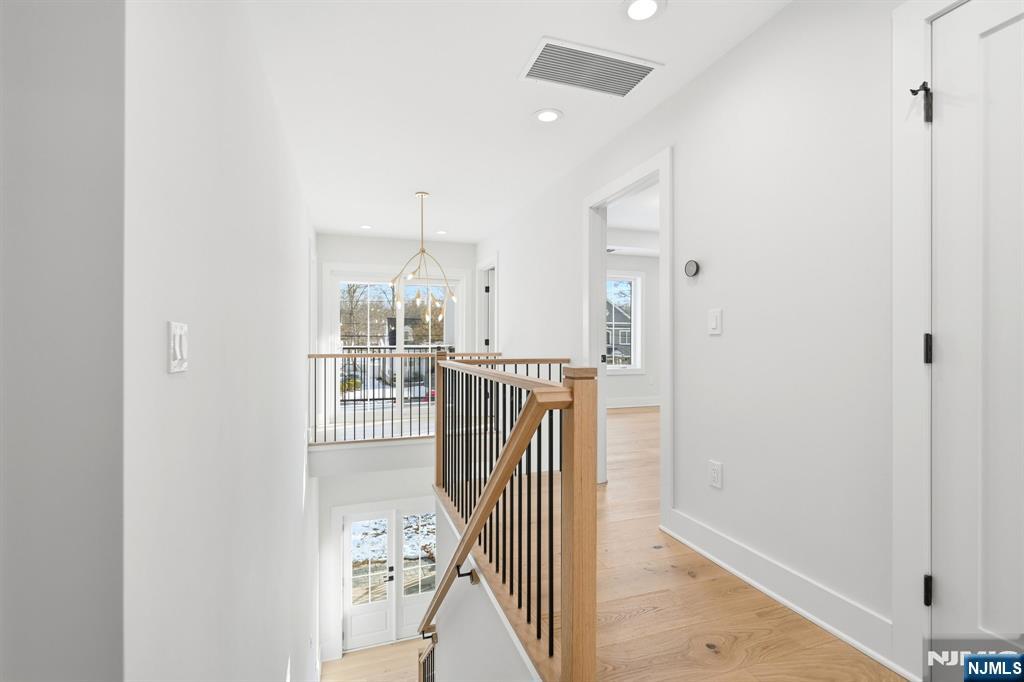8 Montgomery Road Livingston, NJ 07039 - Photo 20 of 38 a view of a hallway with wooden floor and entryway