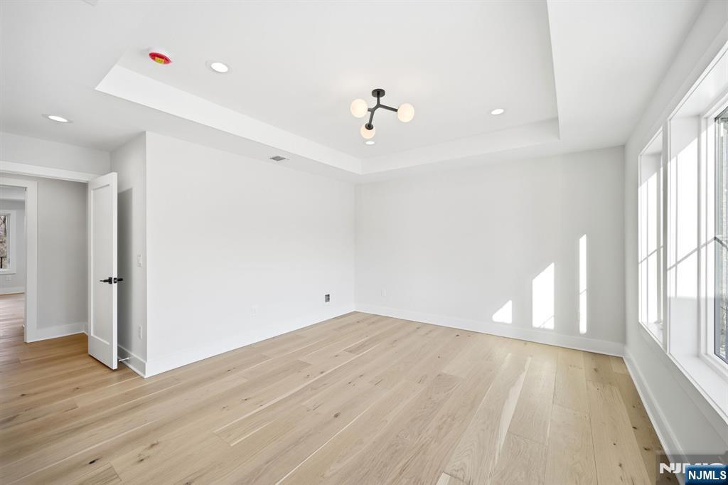 8 Montgomery Road Livingston, NJ 07039 - Photo 24 of 38 an empty room with wooden floor and windows