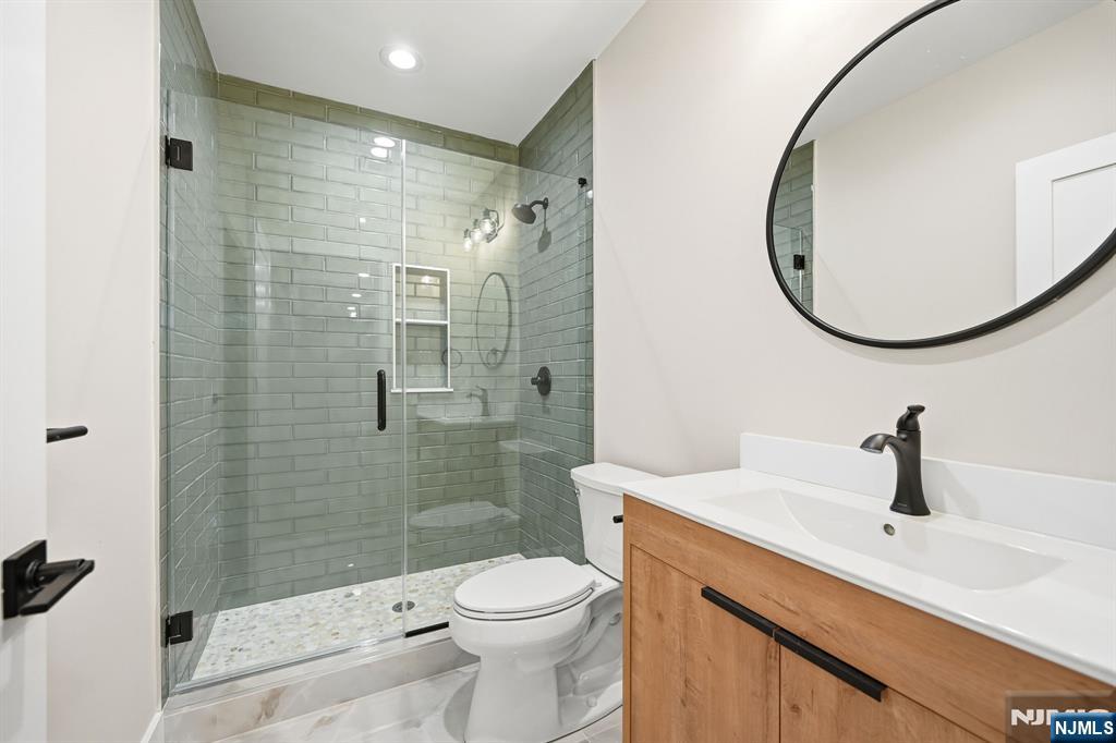 8 Montgomery Road Livingston, NJ 07039 - Photo 36 of 38 a bathroom with a sink a toilet and shower