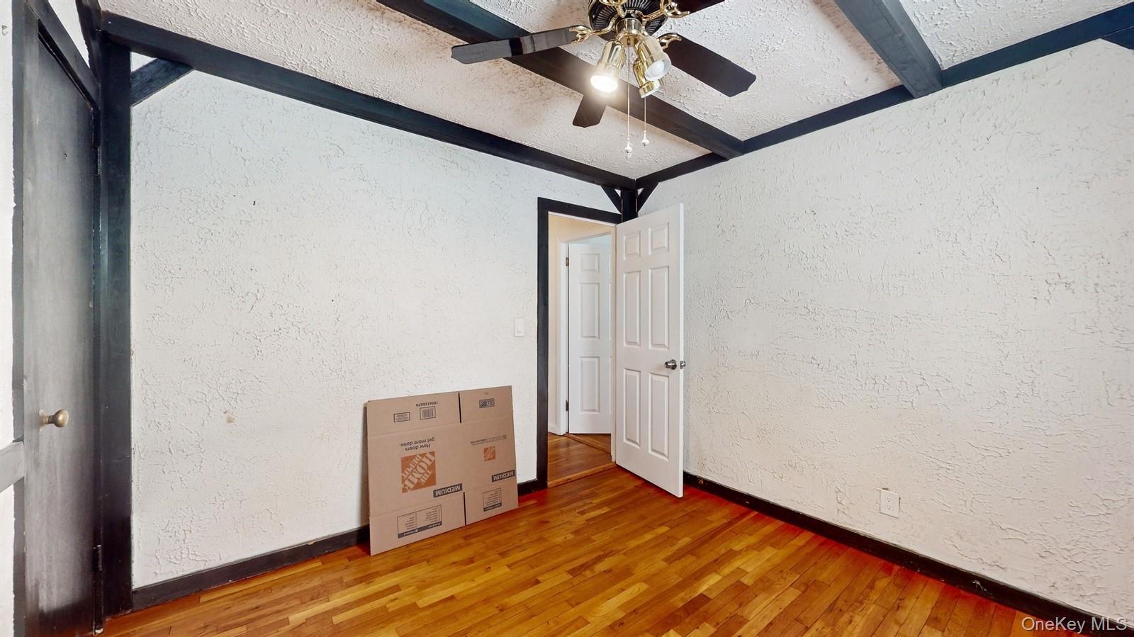 10 Rumbrook Road Elmsford, NY 10523 - Photo 13 of 25 Unfurnished bedroom with hardwood / wood-style flooring, ceiling fan, and beam ceiling