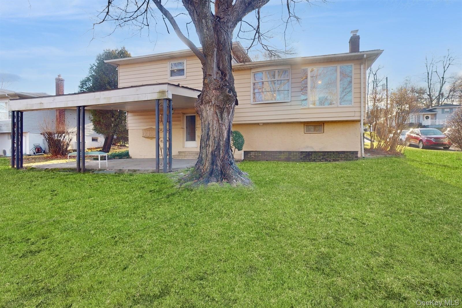 10 Rumbrook Road Elmsford, NY 10523 - Photo 20 of 25 Back of house featuring a lawn and a patio area
