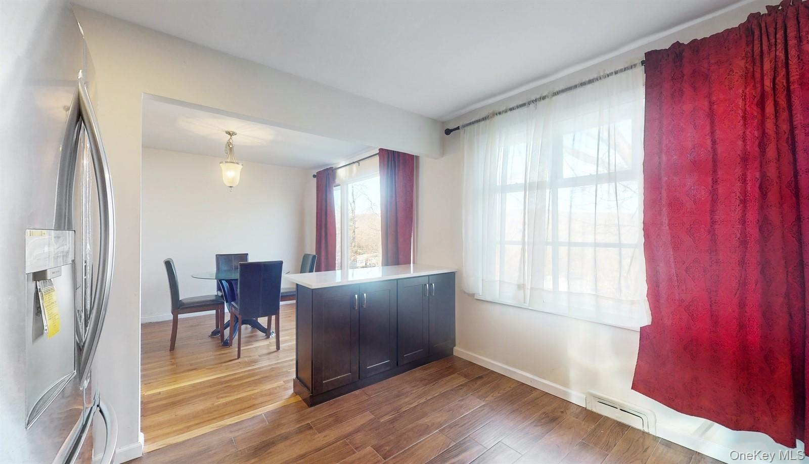 10 Rumbrook Road Elmsford, NY 10523 - Photo 9 of 25 Kitchen with decorative light fixtures, stainless steel fridge, kitchen peninsula, and dark hardwood / wood-style floors