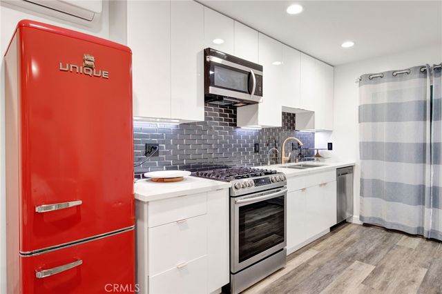 a kitchen with stainless steel appliances granite countertop a stove a sink and a refrigerator