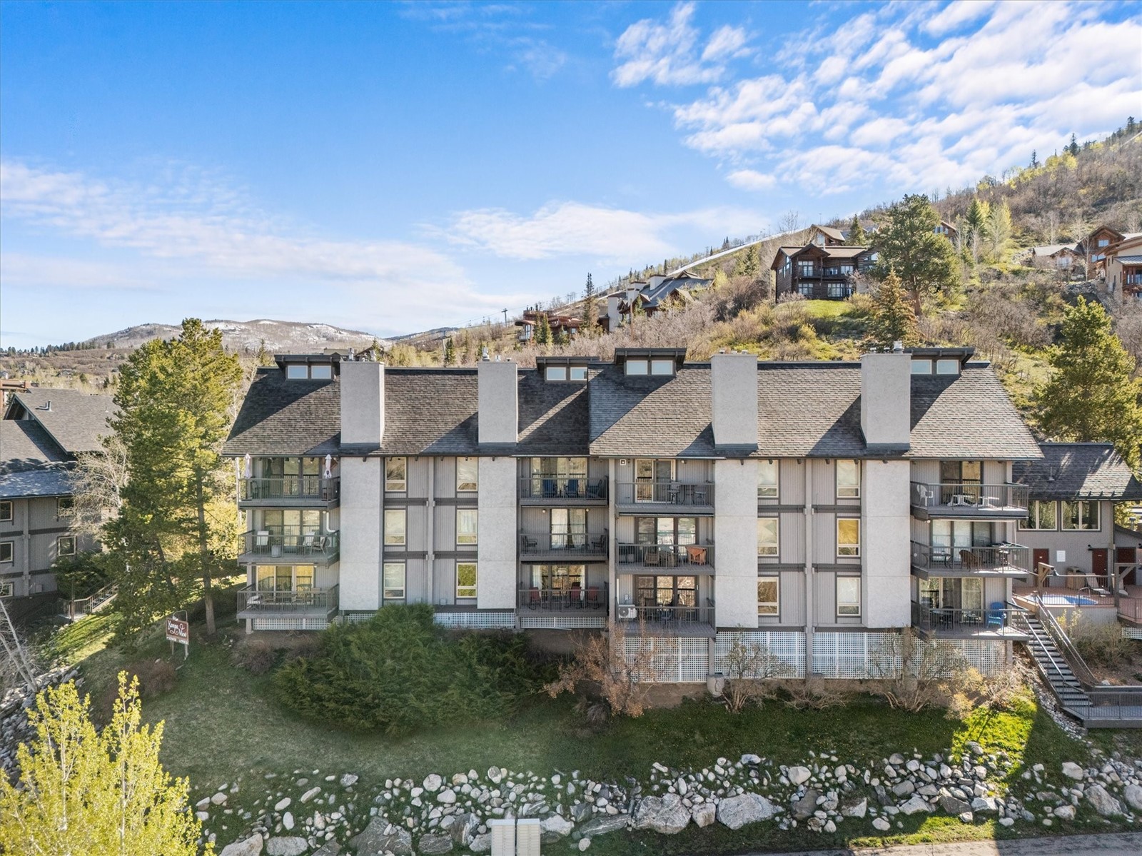 2602 Longthong Road, Unit 107 Steamboat Springs, CO 80487 - Photo 17 of 32 a view of a large building with a big yard and large trees