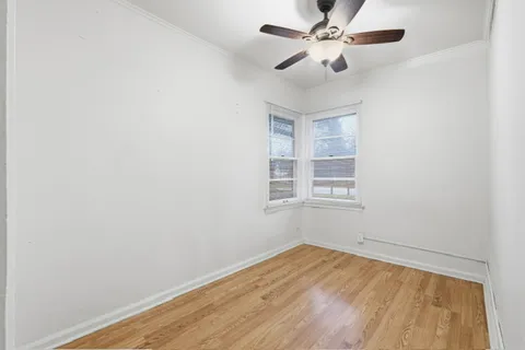 an empty room with a window and a ceiling fan