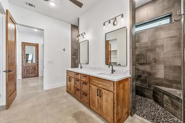 a bathroom with a double vanity sink mirror and shower