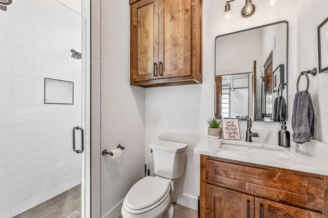 a bathroom with a toilet a sink and mirror
