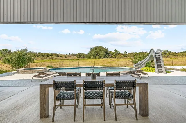 an aerial view of a house with swimming pool and furniture