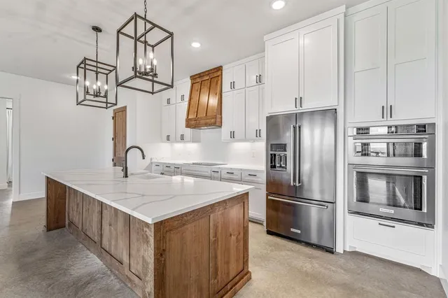 a kitchen with stainless steel appliances granite countertop a sink and refrigerator