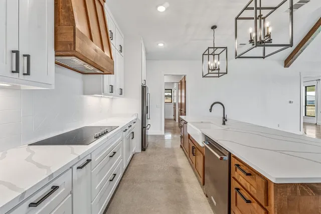 a kitchen with stainless steel appliances granite countertop a sink and dishwasher a stove top oven with wooden floor