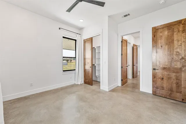 an empty room with windows and cabinet
