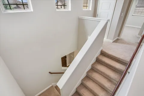 a view of staircase with railing and white walls