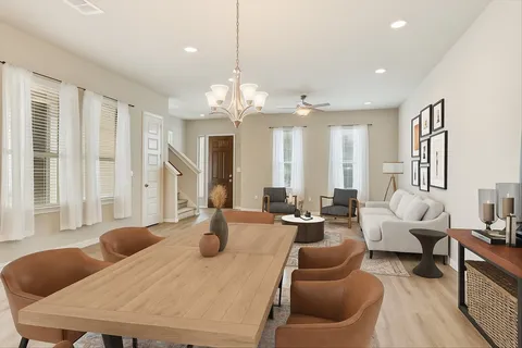 a living room with furniture kitchen and a large window