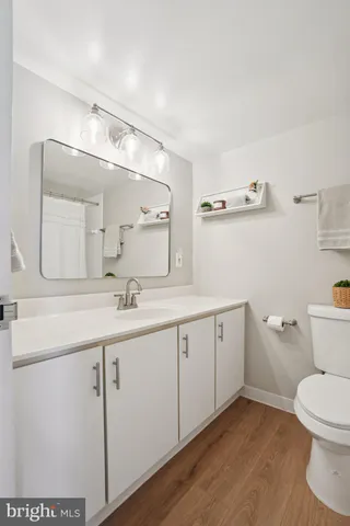 a spacious bathroom with a granite countertop sink a toilet and a mirror