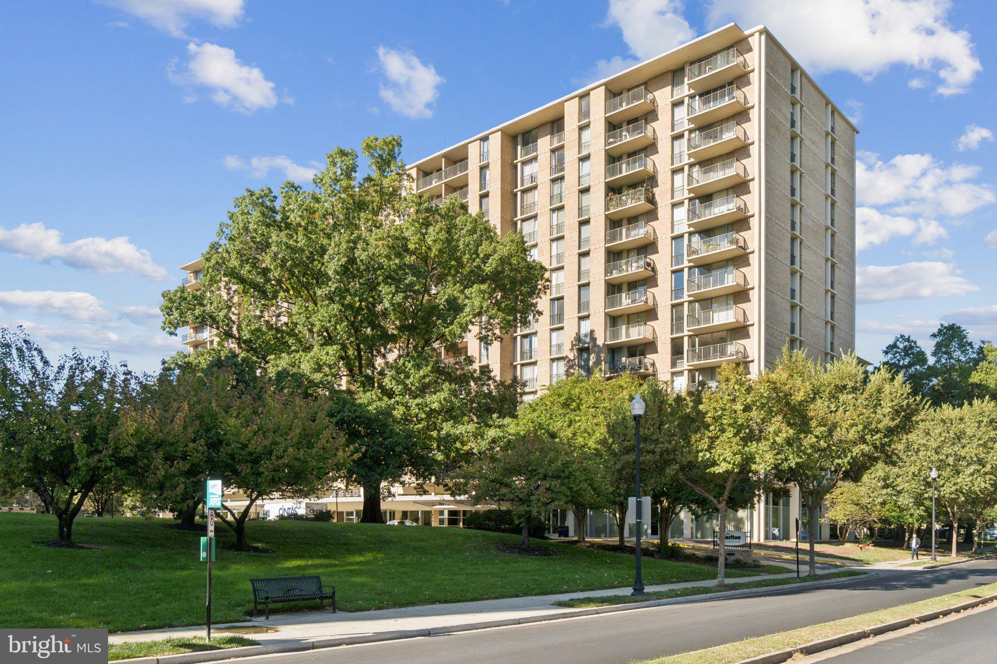 4600 South Four Mile Run Drive, Unit 842 Arlington, VA 22204 - Photo 22 of 24 a view of a tall building next to a big yard and large trees