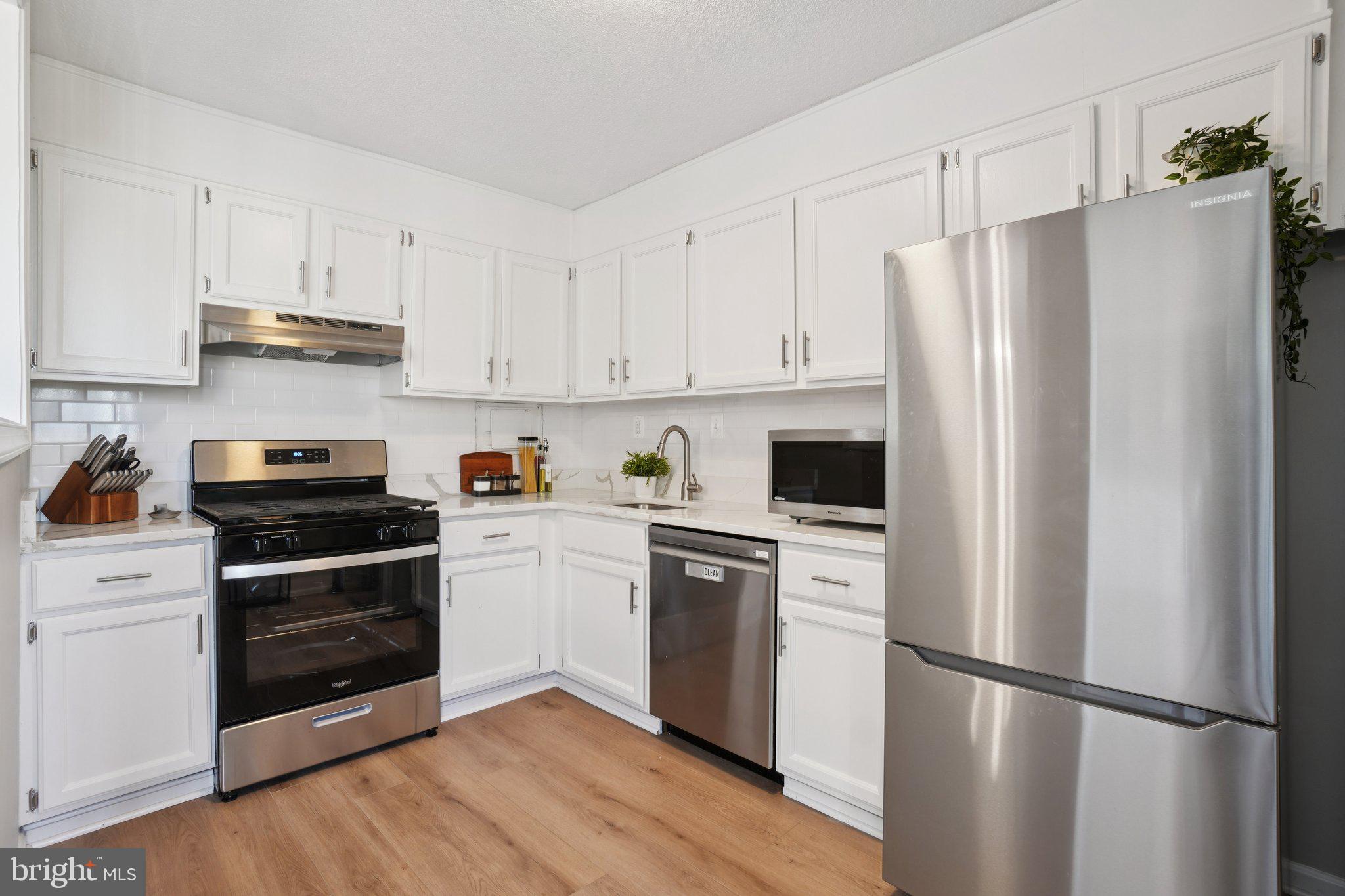 4600 South Four Mile Run Drive, Unit 842 Arlington, VA 22204 - Photo 8 of 24 a kitchen with cabinets stainless steel appliances and wooden floor