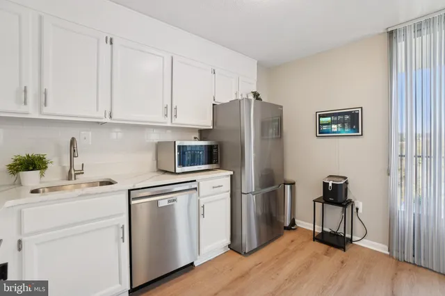 a kitchen with a refrigerator sink and cabinets