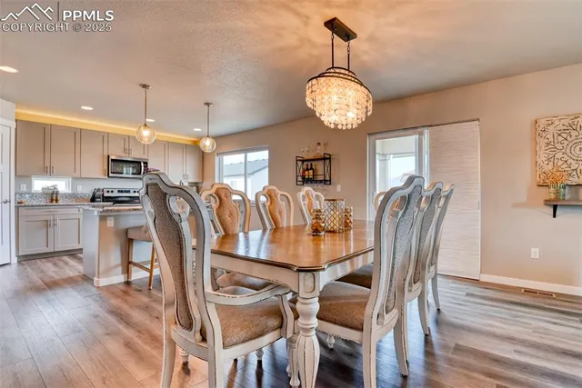 a view of a dining room with furniture wooden floor and chandelier