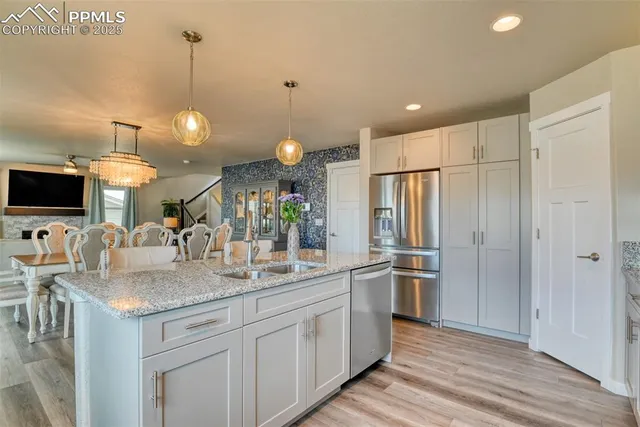 a kitchen with stainless steel appliances granite countertop a sink and a refrigerator