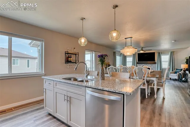 a kitchen with stainless steel appliances granite countertop a sink a stove and a wooden floors
