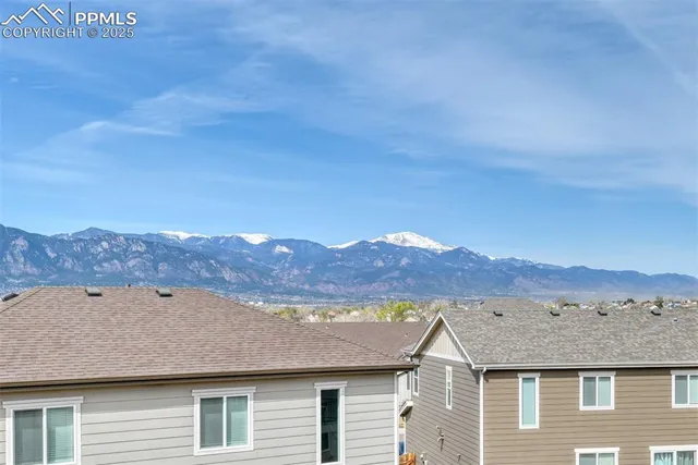 a view of a big house with mountains in the background