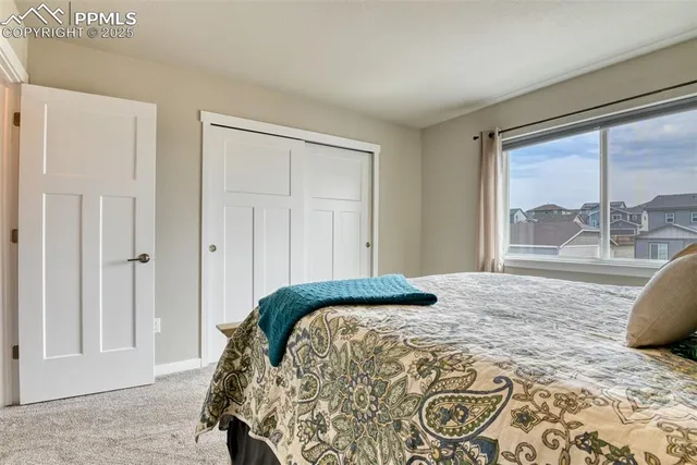 a bedroom with a large bed and a window