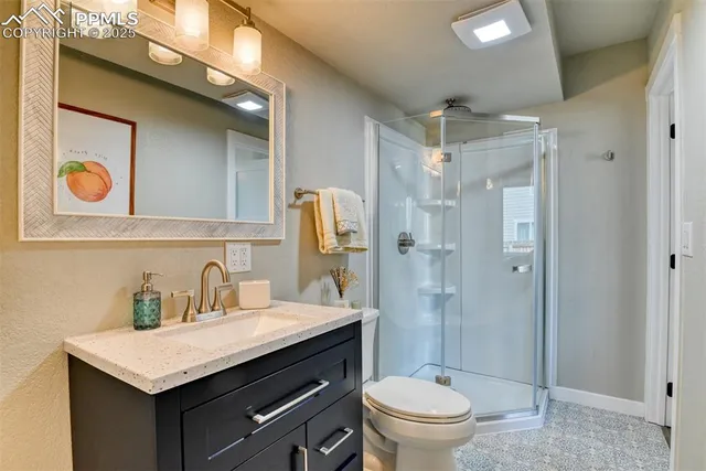 a bathroom with a granite countertop sink toilet and shower