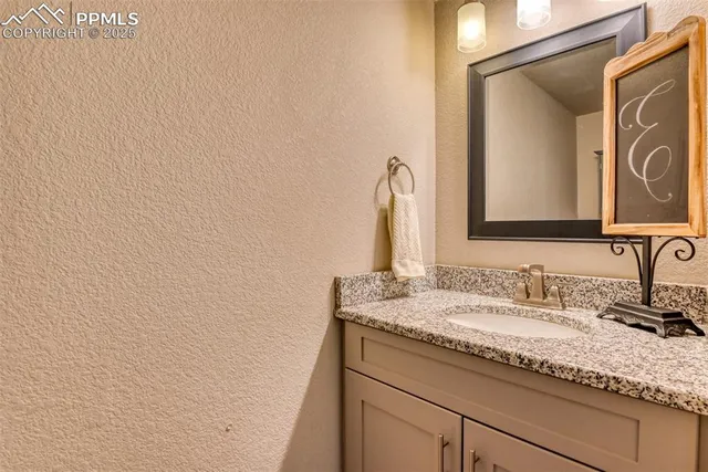 a bathroom with a granite countertop sink and a mirror