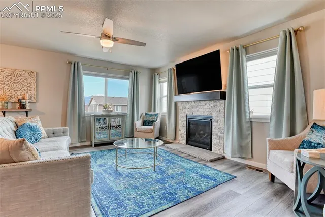 a living room with furniture a flat screen tv and a fireplace