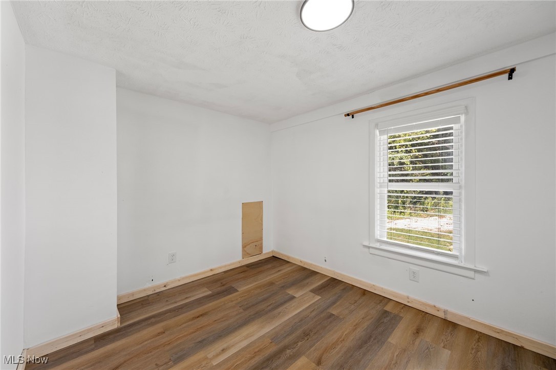 793 Chaffin Road Akron, OH 44306 - Photo 16 of 28 Unfurnished room with dark hardwood / wood-style floors and a textured ceiling
