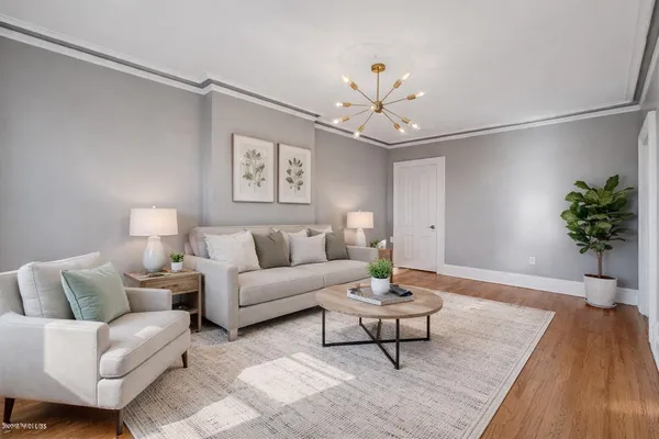 a living room with furniture and a chandelier