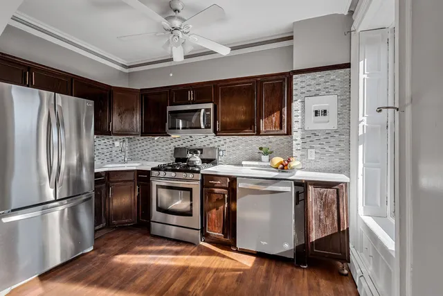 a kitchen with stainless steel appliances granite countertop a refrigerator a stove a sink and a microwave