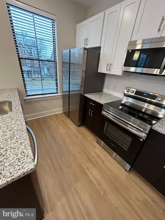 a kitchen with stainless steel appliances wooden cabinets a stove and a refrigerator