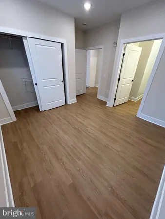 an empty room with wooden floor and stairs