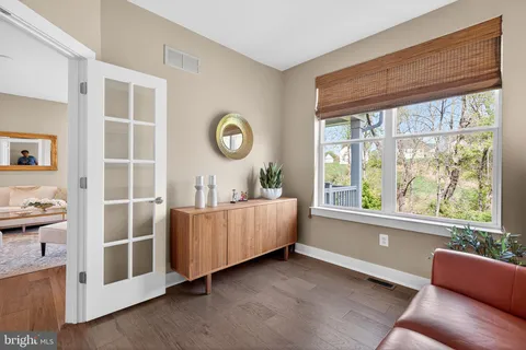a bathroom with a granite countertop toilet a sink a mirror and a window