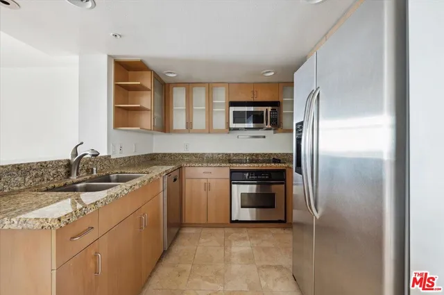 a kitchen with stainless steel appliances granite countertop a refrigerator and a sink