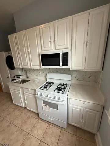 a kitchen with appliances a sink and cabinets