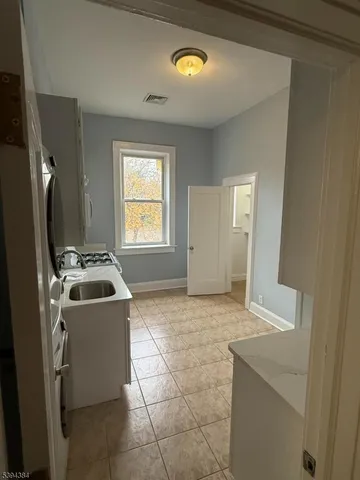 a view of a kitchen with a sink stove and cabinet