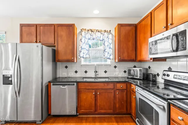a kitchen with stainless steel appliances granite countertop a refrigerator and a stove top oven