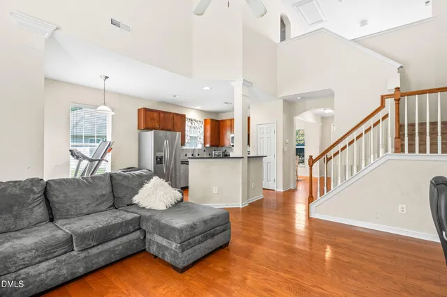 a living room with furniture and a dining table with wooden floor