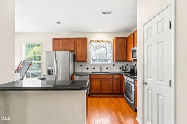 a kitchen with sink a refrigerator and cabinets